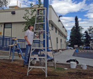 A worker paints outside at the redesigned Access Alaska Building. Photo by Daysha Eaton, KSKA - Anchorage.