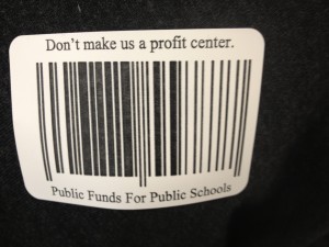 Students at West High School handed out stickers Friday with an image of a bar code and the words, "Don't make us a profit center. Public Funds for Public Schools" on them. Students are wearing the stickers to protest proposed budget cuts in the Anchorage School District.