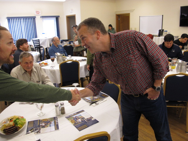 Sullivan greets Leif Albertson at the Bethel Chamber of Commerce lunch. (Photo by Ben Matheson / KYUK)