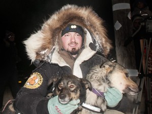 Pete Kaiser at the 2015 Kuskokwim 300 finish with his lead dogs, Palmer and Rosie. – Photo by Chris Pike