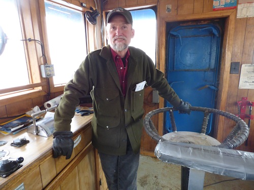 Dan Magone stands in the wheelhouse of the salvage vessel Redeemer. (Annie Ropeik/KUCB)