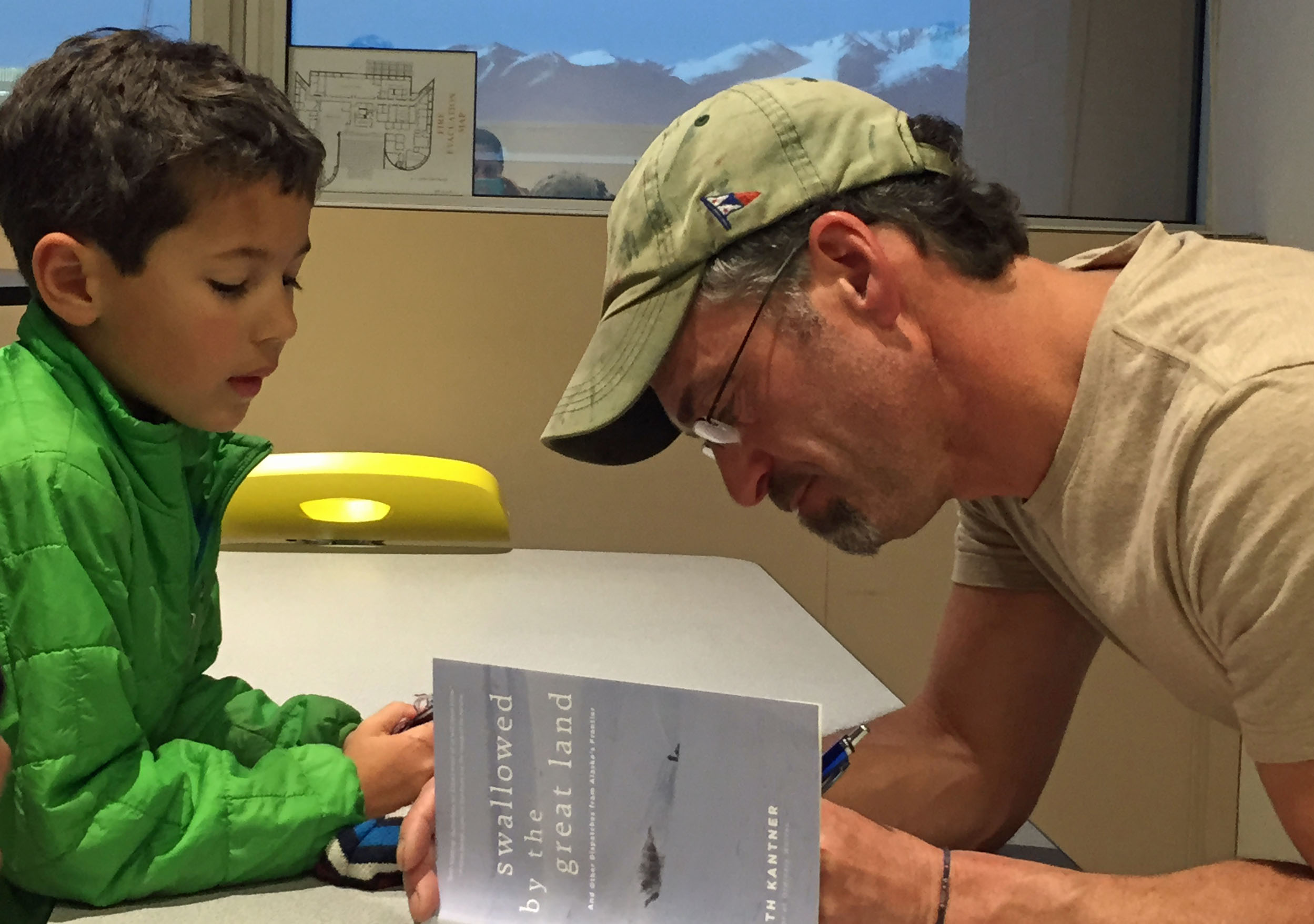 Seth Kantner signs a copy of his new book for a young fan. (Photo by Lori Townsend/APRN)