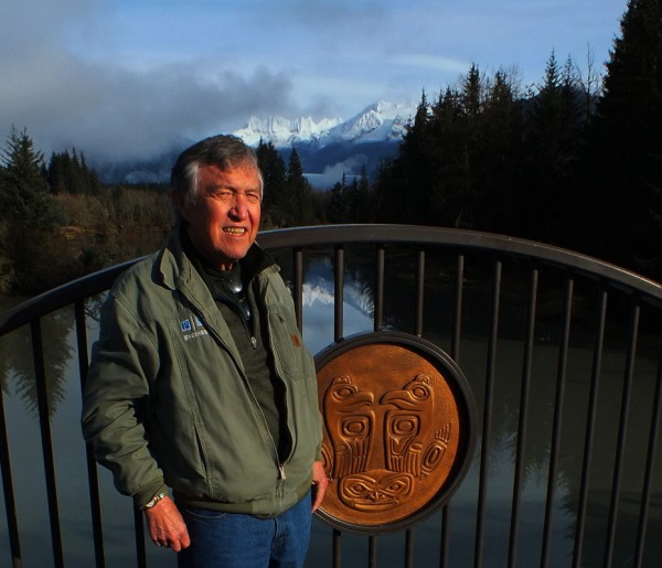 Roy Peratrovich Jr. stands next to one of the bronze medallions he designed for the first Brotherhood Bridge created in 1965. The medallions were recovered, restored and installed on the new Brotherhood Bridge that was dedicated on Saturday. (Photo by Matt Miller/KTOO)