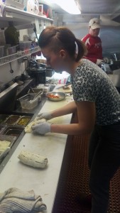 Mackenzie Moen assembles an order of the food truck's tacos. (Photo by Josh Edge/APRN)