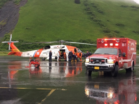 The U.S. Coast Guard and emergency medical personnel transfer patients from a MH-60 Jayhawk helicopter to an ambulance in Kodiak, Alaska, June 2, 2016. The helicopter crew responded to a report of a fire at the Park's Cannery near Uyak Bay on Kodiak Island. (Courtesy photo by U.S. Coast Guard)