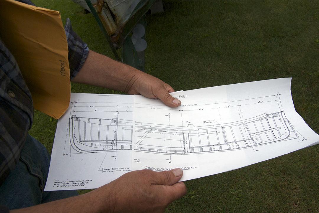Johansen shows the plans for his dad's old boat, built in the winter of 1931-1932 in the Seattle area. (Photo by Jenny Neyman, KBBI - Homer)