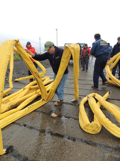 Dr. Rick Bernhardt from the Alaska Department of Environmental Conservation shows volunteers how to stage containment boom Tuesday morning at the Dillingham boat harbor. (Photo by Shaylon Cochran, KDLG - Dillingham)