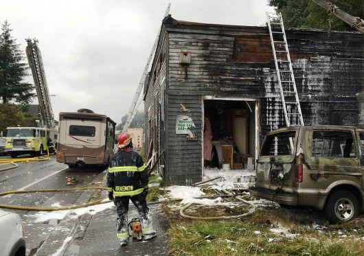 Firefighter Seth Krasnow watches the progress of fire crews as they make sure hot spots are extinguished in a Stedman Street building that caught fire Wednesday. (Leila Kheiry, KRBD - Ketchikan)