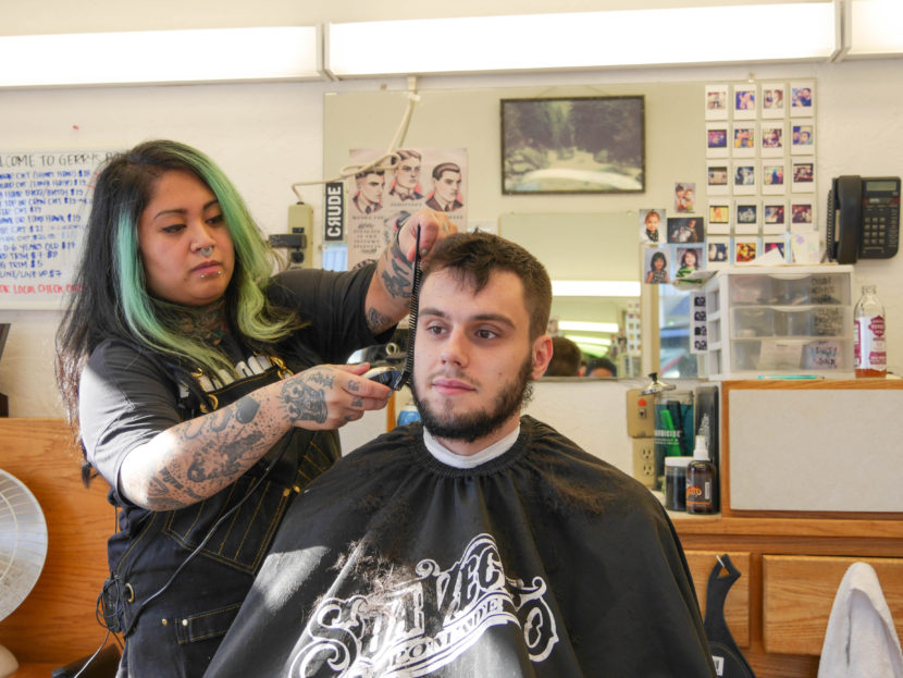 Eva Carrillo cuts Kyle White’s hair at Gerry’s Barbershop. Kyle has been going to the shop since he was a kid. (Photo by Lakeidra Chavis, KTOO - Juneau)