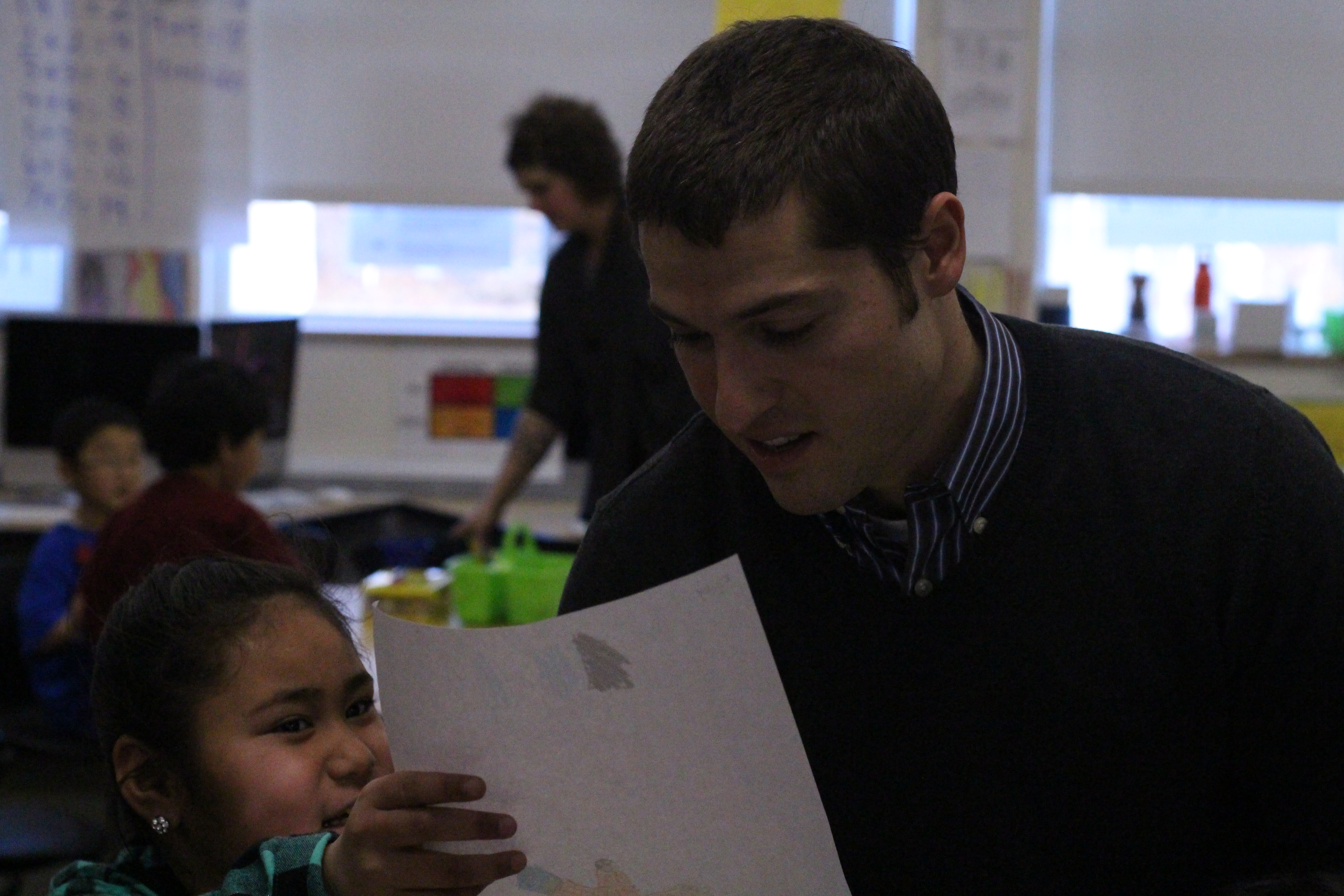 One of Paul Campbell's students shows him a drawing she made. (Photo by Wesley Early, Alaska Public Media - Anchorage)
