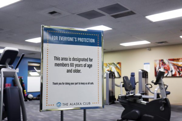 A sign at Alaska Club East notifies members that a section of the fitness center is reserved for people age 60 and older.