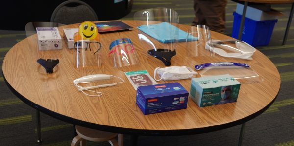 A variety of face masks and face shields displayed on a table at Huffman Elementary School.