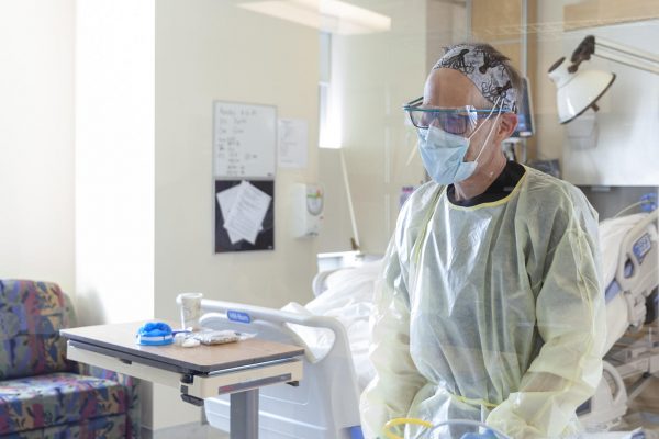A health care provider in full personal protective equipment in a Juneau hospital room.
