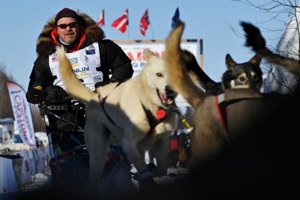 An Iditarod musher and sled dogs