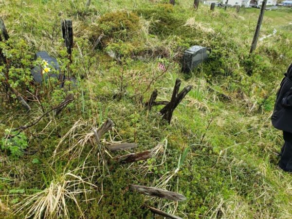 An unmarked grave in steep grass