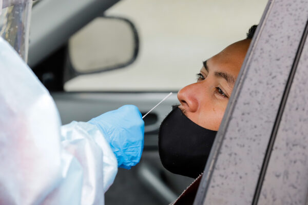 a medical professional swabs a driver's nostril
