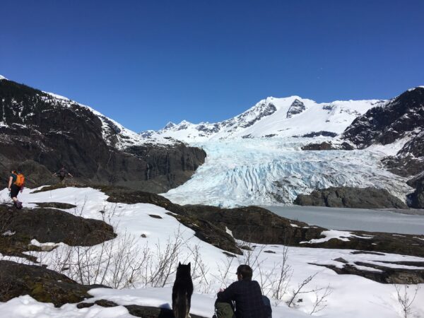 A glacier and snowy mountain with hikers.