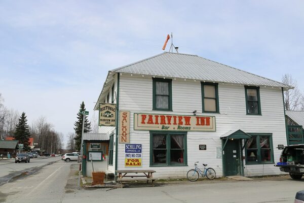 A two-story white building with a sign that says Fairview Inn.