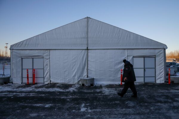 a person walks by a large tent
