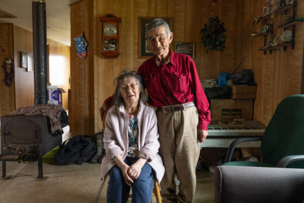 A man and woman pose for a photo in a house.