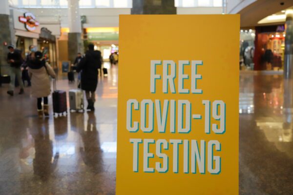 un signe qui dit "test covid-19 gratuit" dans un aéroport