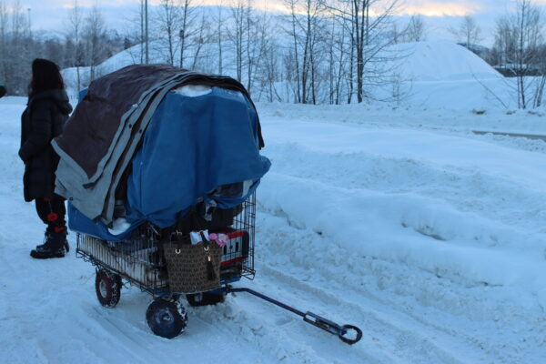 A cart filled with tarps and other items on the on a snowy trail