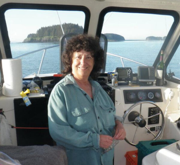 A woman in a button-up shirt on a boat.