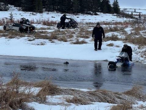Searches pull a snowmachine out of water.