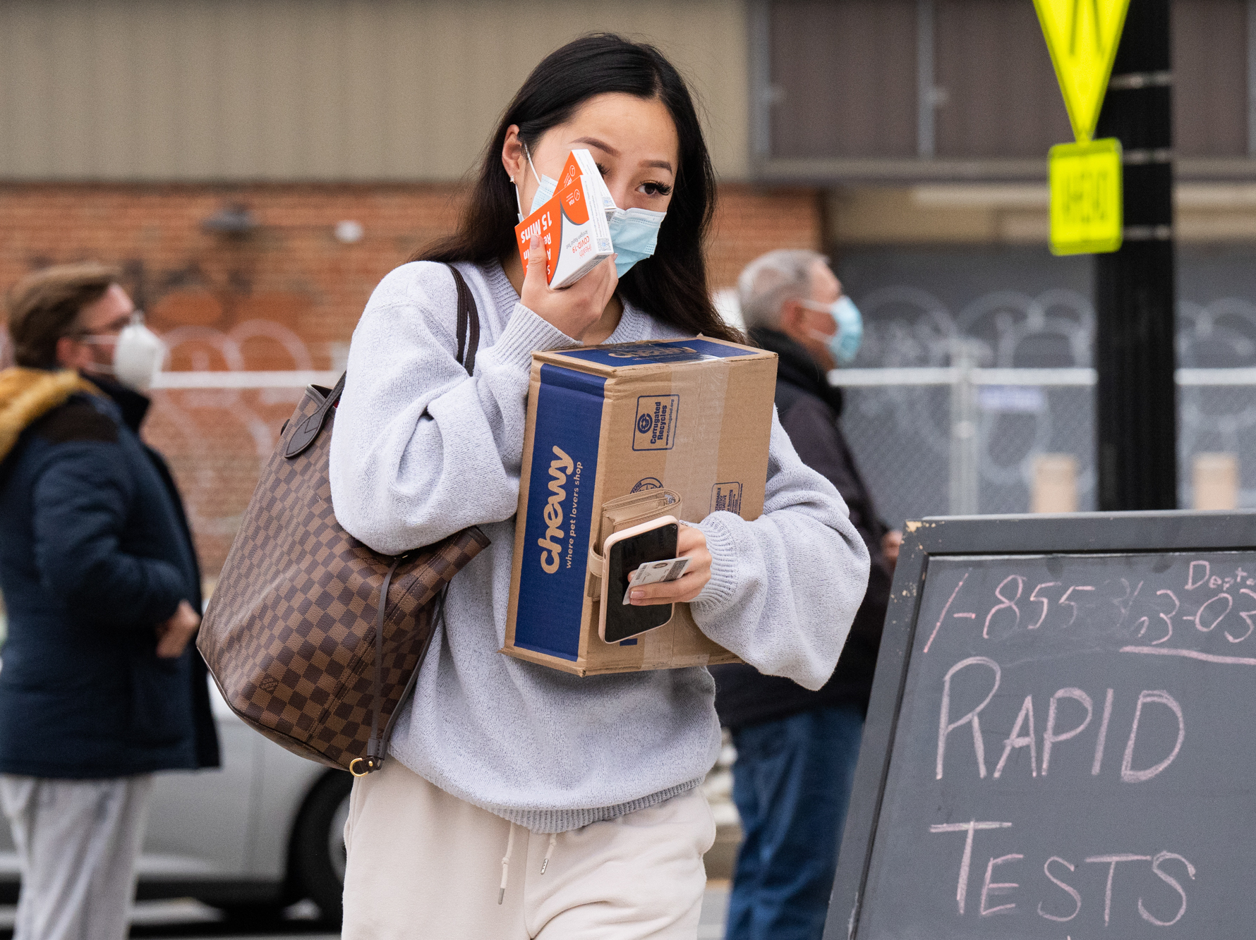 Woman walking with box and wearing a mask