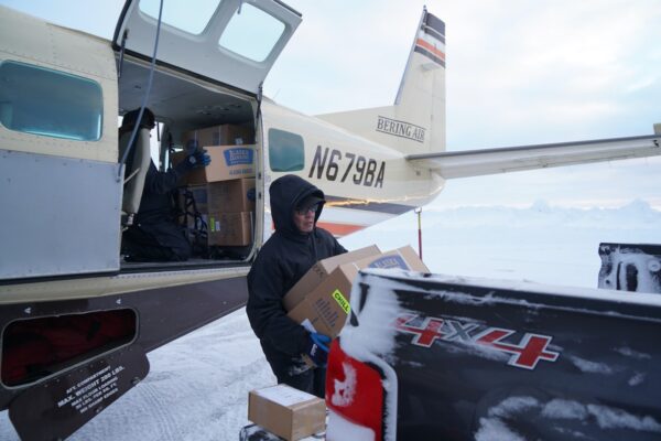 a person offloads boxes from a small plane