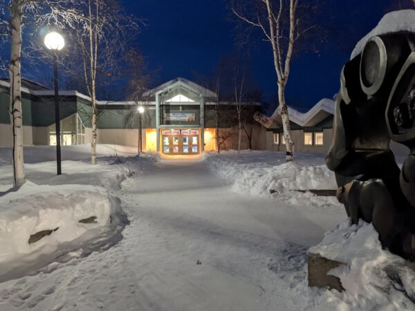 The outside of a school building on a snowy evening