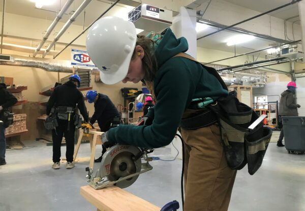 Girl cutting wood with saw
