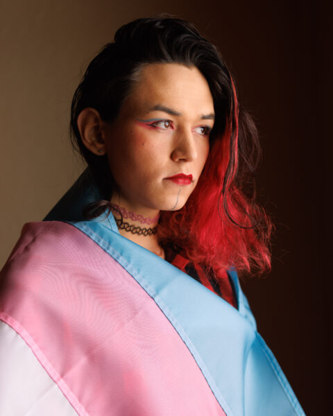 A woman draped in a trans pride flag