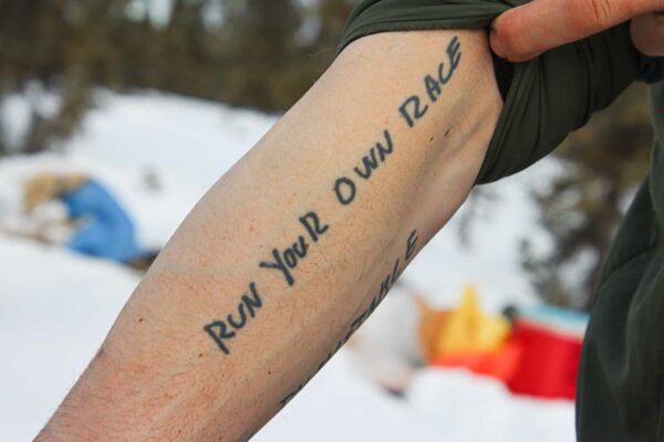 A tattoo says: Run Your Own Race