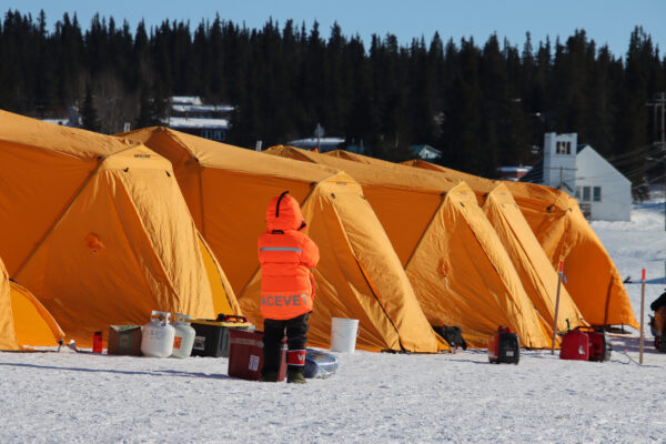 A row of orange tents in a snowy area