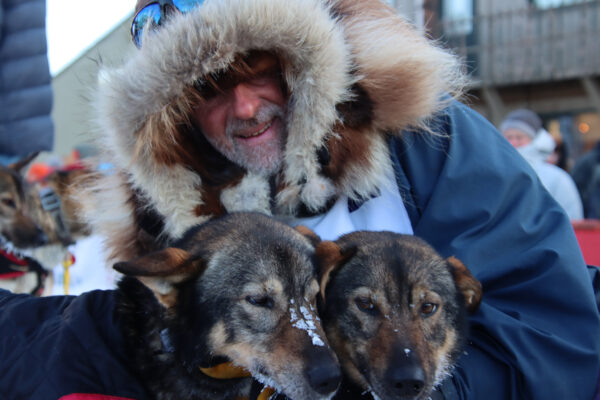 A man holds two dogs