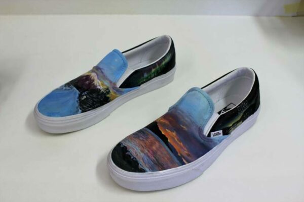 A pair of slip-on vans with Alaskan landscape designs printed on them
