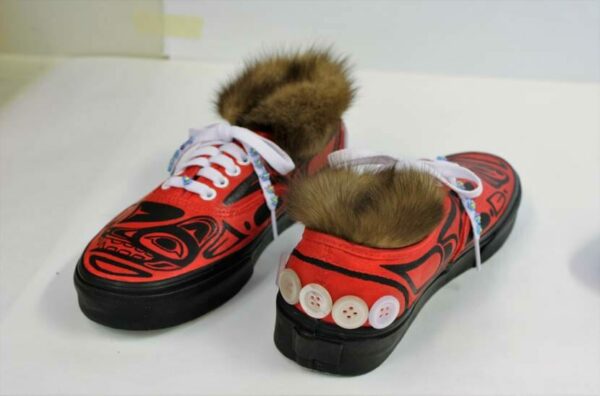La même paire de chaussures rouges, avec une touche pour montrer les boutons cousus dans le talon