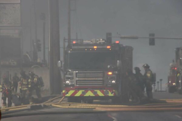 a smokey photo of firefighters and a fire truck on a roadway