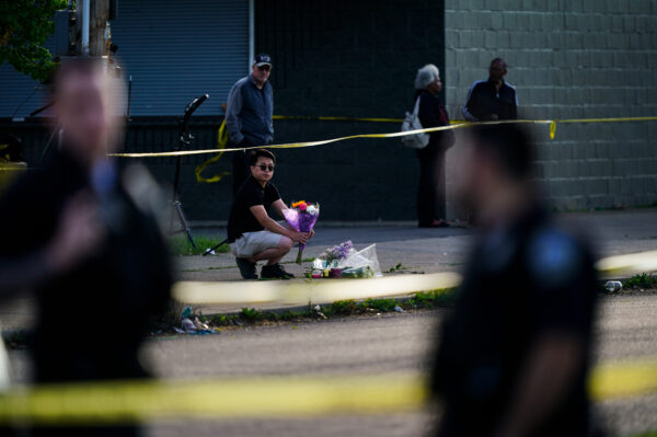 a person with flowers near police tape