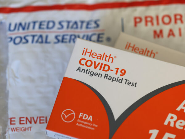 a covid-19 test and a postal service envelope