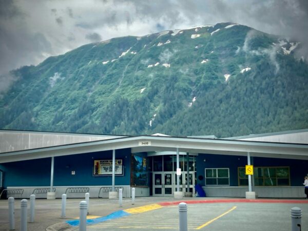 The entrance of a school with a mountain behind it