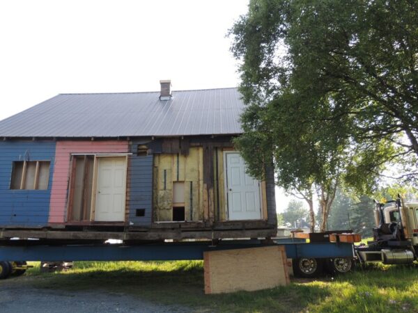 a blue and pink house gets moved